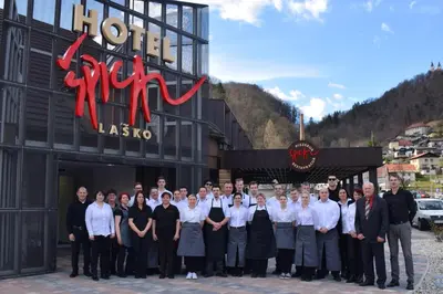 a group of people posing for a picture in front of a building at Hotel Špica Laško in Laško