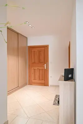 a room with a wooden door and a tiled floor at Apartment Štros with private sauna in Kranjska Gora