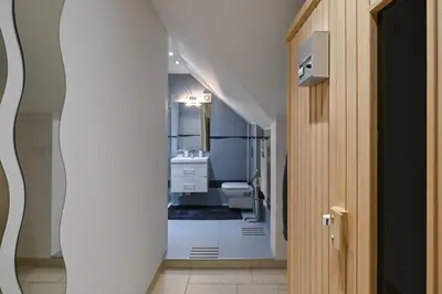a hallway leading to a bathroom with a toilet and sink at Apartment Štros with private sauna in Kranjska Gora