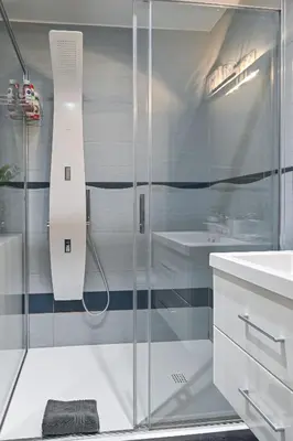 a glass shower in a bathroom with a sink at Apartment Štros with private sauna in Kranjska Gora