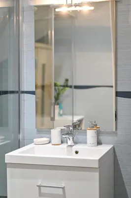 a bathroom with a white sink and a mirror at Apartment Štros with private sauna in Kranjska Gora
