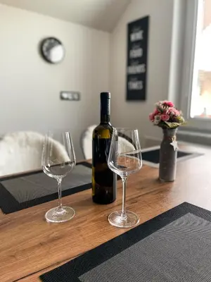 a bottle of wine and two wine glasses on a table at Apartment Landscape in Zgornje Gorje