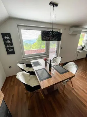 a dining room table with white chairs and a window at Apartment Landscape in Zgornje Gorje