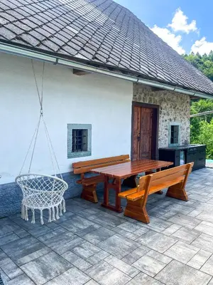 a patio with benches and a table and a grill at Apartment Landscape in Zgornje Gorje