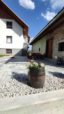 a barrel with flowers in it in front of a building at Apartment Landscape in Zgornje Gorje