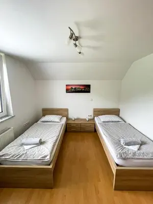 two twin beds in a room with wooden floors at Apartment Landscape in Zgornje Gorje
