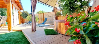 a patio with a deck with a chair and flowers at RIVER KOLPA APARTMENT, Griblje ob reki Kolpi in Gradac
