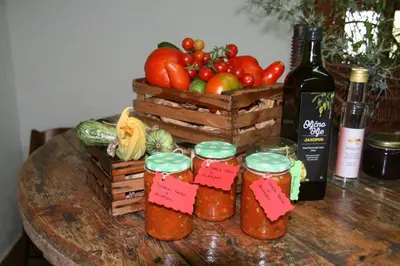 a table with a basket of vegetables and jars of jam at Camping Jakomin in Koper