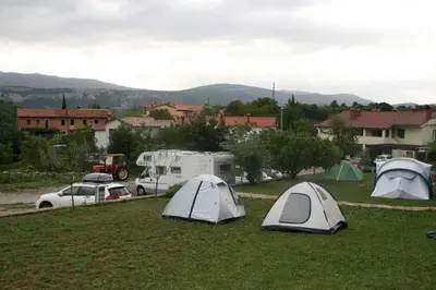 a group of tents in a field with cars at Camping Jakomin in Koper