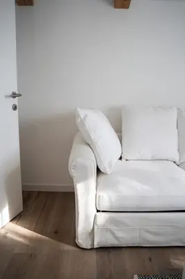 a white couch sitting in a living room at 9b-The Resort in Sežana