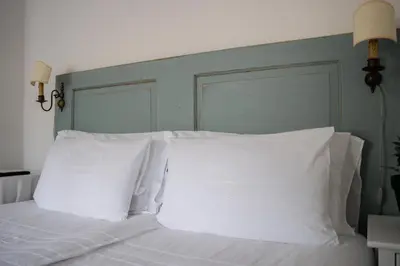 a bed with white pillows and a green headboard at 9b-The Resort in Sežana