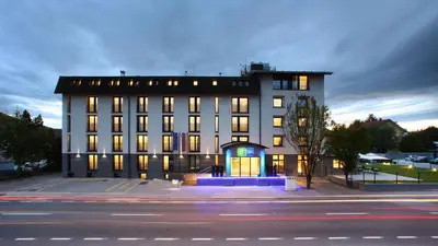 a large white building with lit up windows at Holiday Inn Express - Ljubljana by IHG in Ljubljana