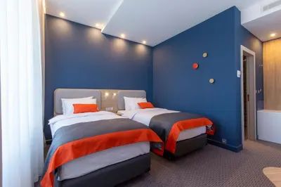 two beds in a room with blue walls at Holiday Inn Express - Ljubljana by IHG in Ljubljana