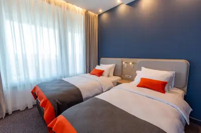 two beds in a hotel room with a window at Holiday Inn Express - Ljubljana by IHG in Ljubljana