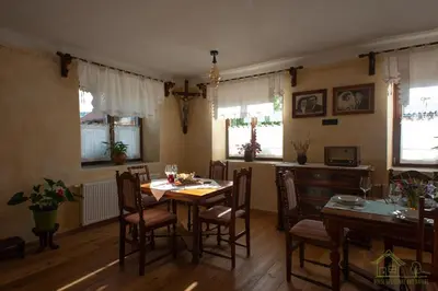 a dining room with a table and chairs and windows at House of Culture and Nature - Hiša Kulture in Nature in Zagradec