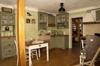 a kitchen with green cabinets and a table in a room at House of Culture and Nature - Hiša Kulture in Nature in Zagradec