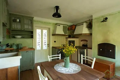 a kitchen with a wooden table with a vase of flowers on it at House of Culture and Nature - Hiša Kulture in Nature in Zagradec