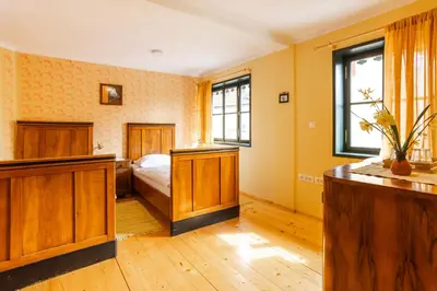 a bedroom with yellow walls and a bed and a window at Hostel Gabronka in Bistrica ob Sotli
