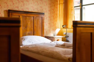 a bedroom with a bed with a wooden headboard and a window at Hostel Gabronka in Bistrica ob Sotli