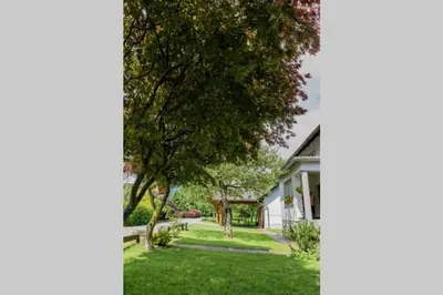 a house with a yard with green grass and trees at APARTMA JANŠA in Bled