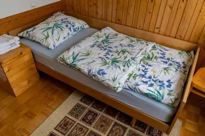 a bed with two pillows on it in a room at APARTMA JANŠA in Bled