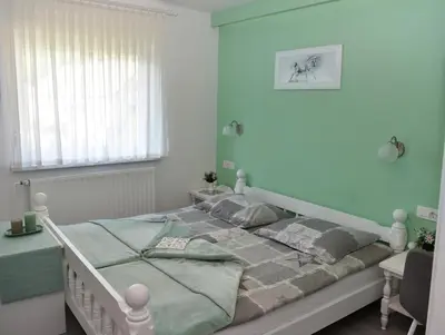 a bedroom with a bed with blue walls at Gostišče Trobej in Gornji Grad