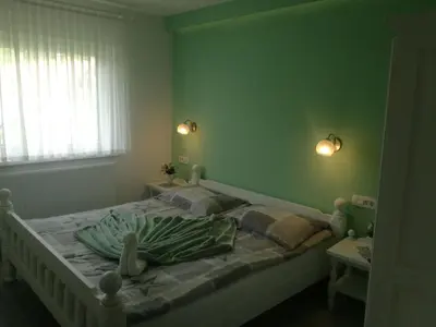 a bedroom with a bed with a green wall at Gostišče Trobej in Gornji Grad