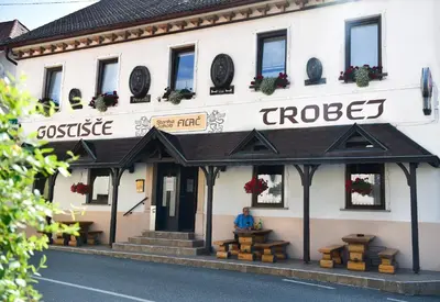 a man sitting in the front of a house at Gostišče Trobej in Gornji Grad