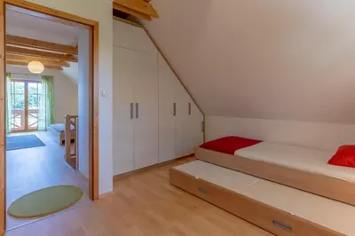 a bedroom with a bed and a staircase in a house at Chalet Haloze in Pristava