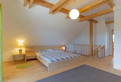 a bedroom with a large bed and a staircase at Chalet Haloze in Pristava