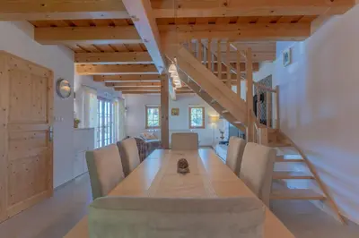 a dining room with a long table and a staircase at Chalet Haloze in Pristava