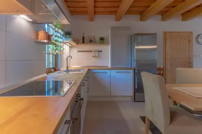 a kitchen with a wooden counter top and a table at Chalet Haloze in Pristava