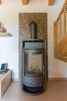a brick fireplace with a stove in a room at Chalet Haloze in Pristava
