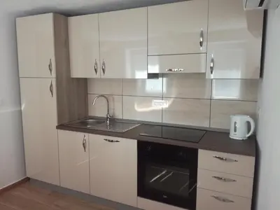 a kitchen with white cabinets and a sink and a stove at Apartma Kambrca in Drežnica