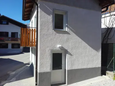 a side view of a house with a white door at Apartma Kambrca in Drežnica
