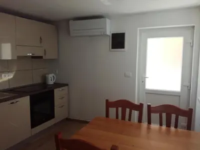 a kitchen with a table and chairs and a window at Apartma Kambrca in Drežnica