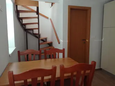 a dining room with a table and chairs and a staircase at Apartma Kambrca in Drežnica