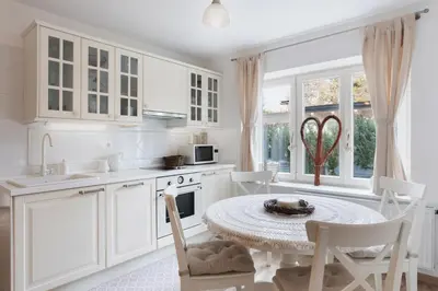 a kitchen with white cabinets and a table and chairs at Historical Villa in the heart of Bled in Bled