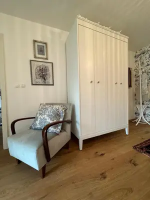 a bedroom with a white cabinet and a chair at Historical Villa in the heart of Bled in Bled