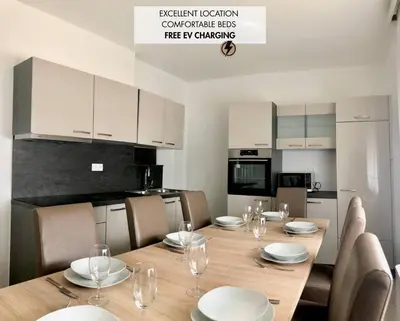 a dining room with a table and chairs and a kitchen at Apartments Andrej - Optuj in Ptuj