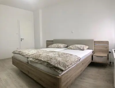 a bedroom with a large bed with white sheets and pillows at Apartments Andrej - Optuj in Ptuj