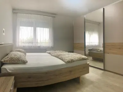 a bedroom with a bed and a large mirror at Apartments Andrej - Optuj in Ptuj