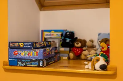 a shelf with games and stuffed animals on it at Apartment Eli in Kranjska Gora