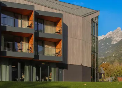 a building with a mountain in the background at Hotel Soča in Bovec