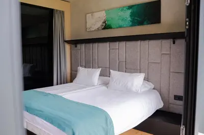 a bed with white sheets and pillows in a room at Hotel Soča in Bovec