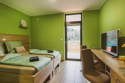a bedroom with two beds and a desk and a television at Center Vintgar in Slovenska Bistrica