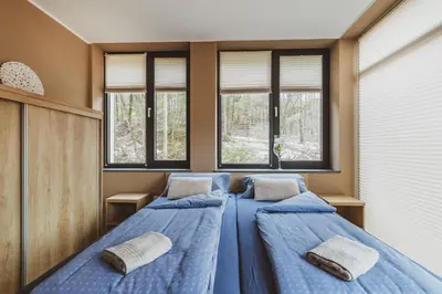 three beds in a room with windows at Center Vintgar in Slovenska Bistrica