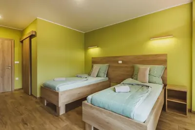 two beds in a room with green walls at Center Vintgar in Slovenska Bistrica