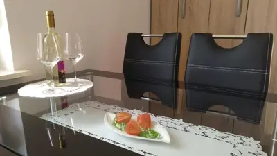 a table with a plate of food and two wine glasses at Apartma Golob in Zgornja Kungota
