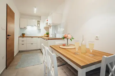 a kitchen with a wooden table with two glasses of champagne at Apartment Via Mons in Kranjska Gora